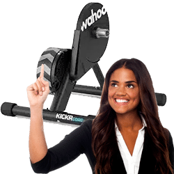 Kvinde viser en Wahoo KICKR Core hometrainer.